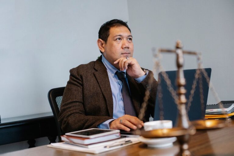 An expert witness sitting at a table thinking.